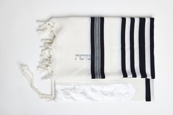 Black striped tallit folded with decorative atarah